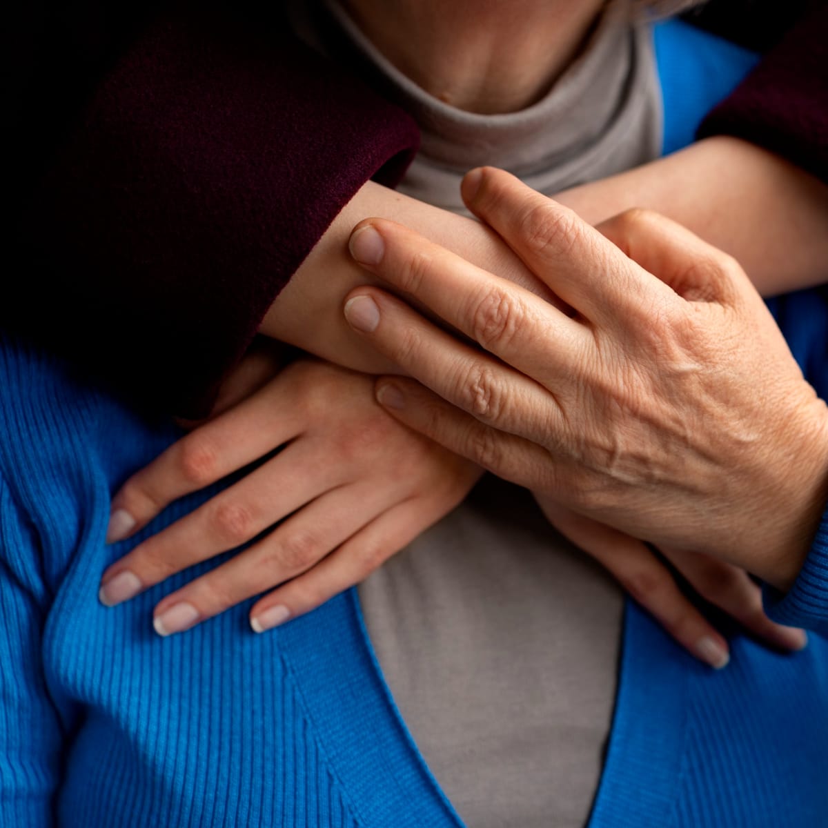Woman putting her hands around her mother from behind